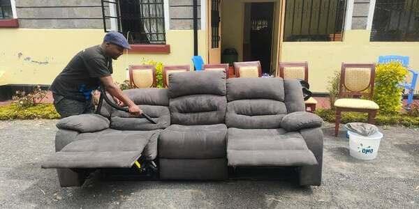 A fabric sofa mid-clean, still showing ground-in dirt