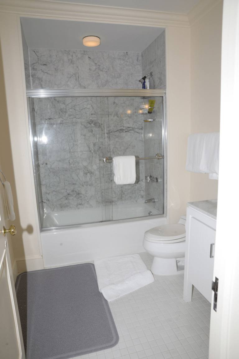 A clean, disinfected bathroom with marble-tiled shower